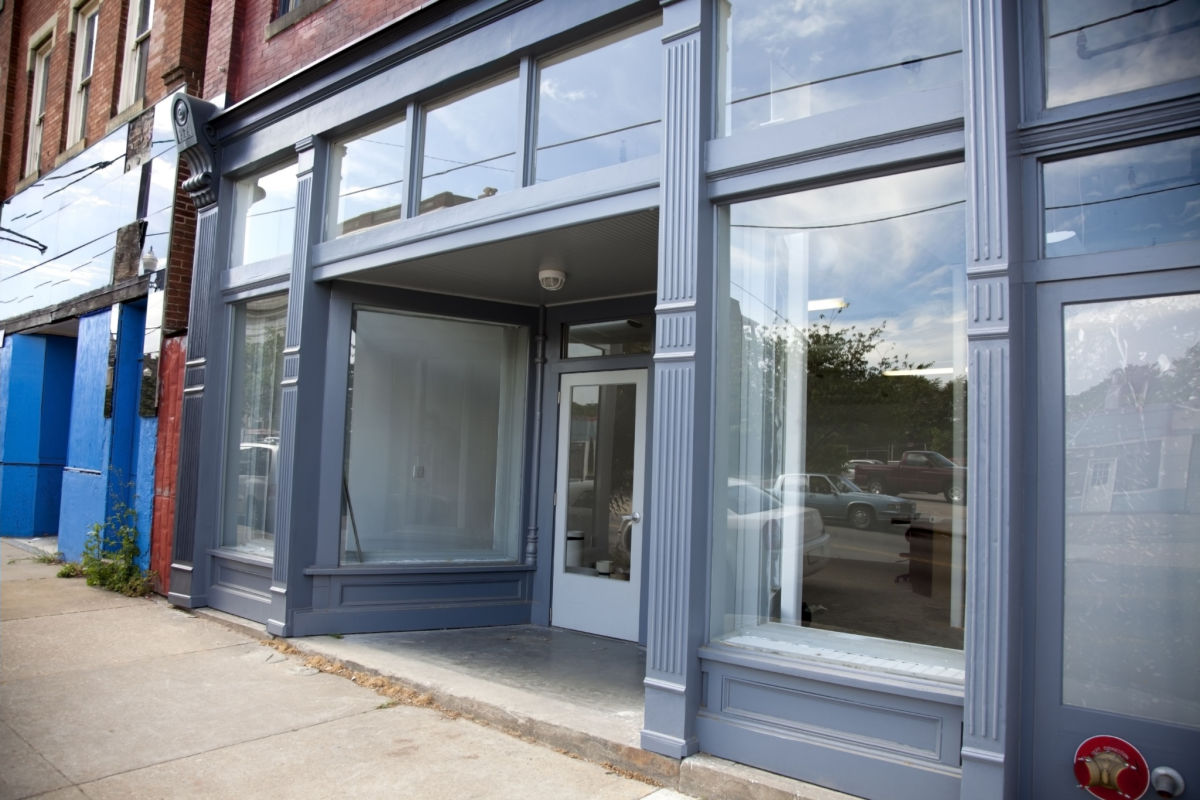 The outside of an empty storefront painted blue.