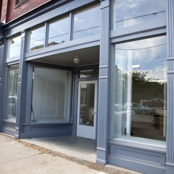 The outside of an empty storefront painted blue, Commercial Window Replacement services near me,
